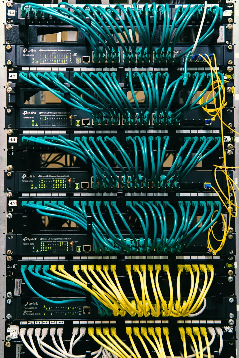 Cat6 kablolarla düzenli bağlanmış switch ve patch panelli veri dolabı